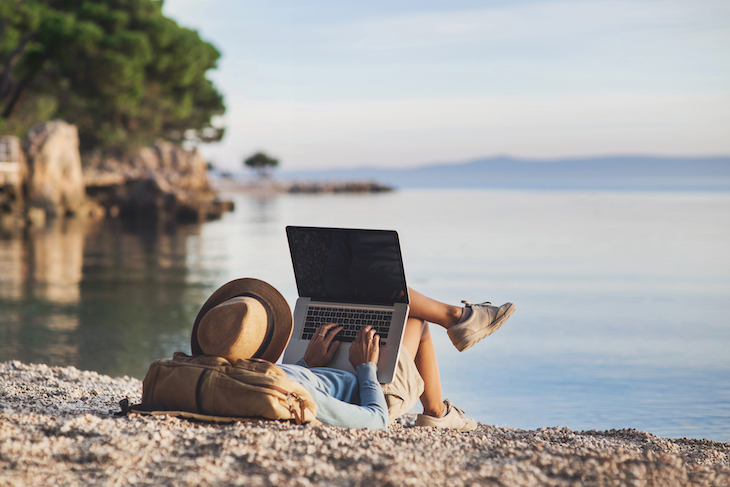Freelancer working with laptop computer on a beach