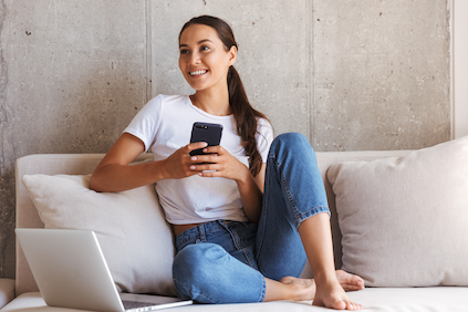 Woman using smartphone while sitting on couch